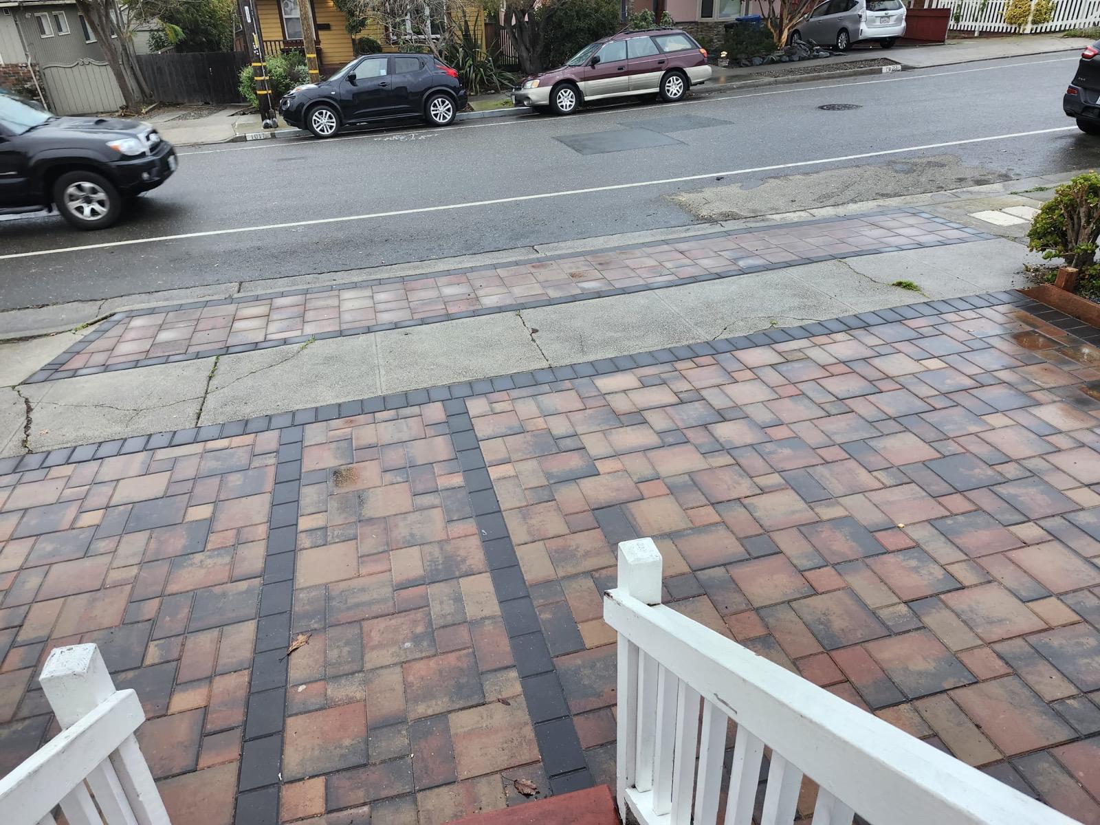 Multi-tone paver front entry and sidewalk strip with charcoal borders seen from the porch